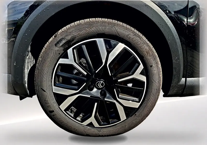 Gros plan sur la roue avant droite noire avec jante alu bicolore du Citroën C4 X 2025 hybride.