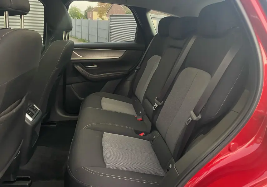 Vue intérieure des sièges arrière en tissu noir et gris du Mazda CX-60 Soul Red Crystal, porte arrière ouverte côté droit.