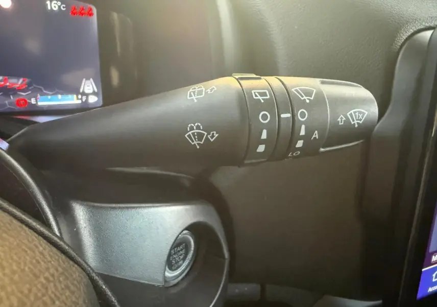 Gros plan sur la commande des essuie-glaces à gauche du volant dans un Jeep Renegade gris anthracite 2024 e-Hybrid Summit.