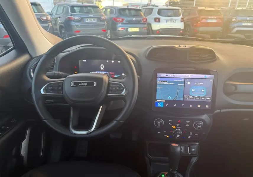 Vue intérieure du tableau de bord du Jeep Renegade 2024 gris anthracite, avec volant multifonction et écran tactile GPS allumé.
