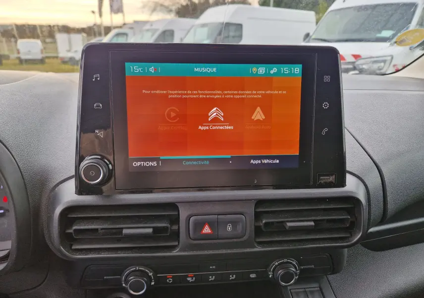 Vue rapprochée de l’écran tactile central du tableau de bord du Citroën Berlingo blanc, affichant les applications connectées.