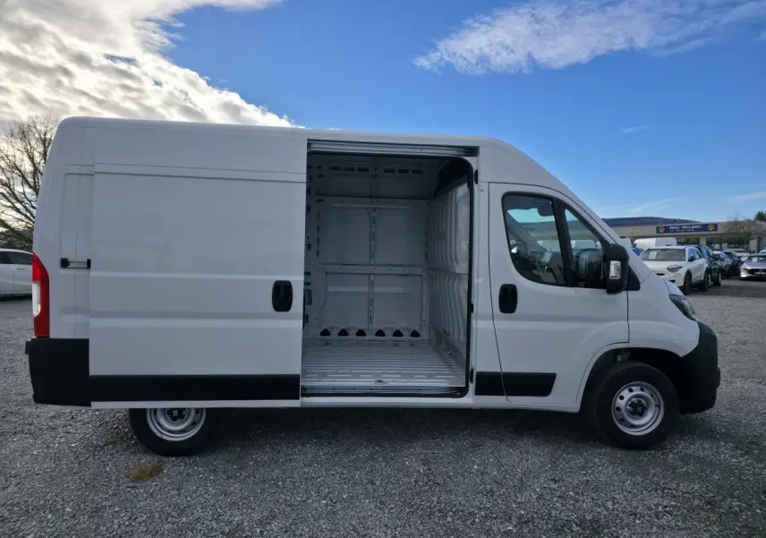 FIAT Ducato Fourgon blanc vue de profil droit avec porte latérale coulissante ouverte montrant l’intérieur tôlé vide.