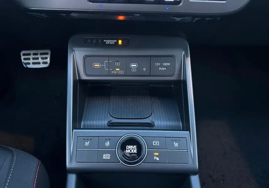 Vue rapprochée de la console centrale du Hyundai KONA II 1.6 Hybrid N Line, avec commandes de modes de conduite et prises USB-C.