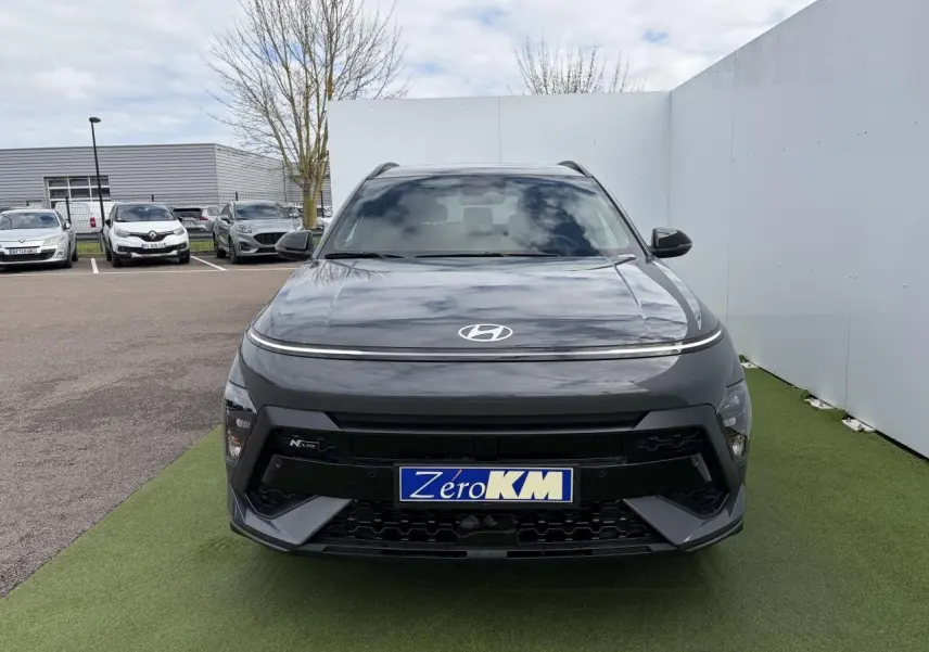 Vue avant d'un Hyundai Kona II N Line gris métallisé Ecotronic avec calandre noire et signature lumineuse fine.
