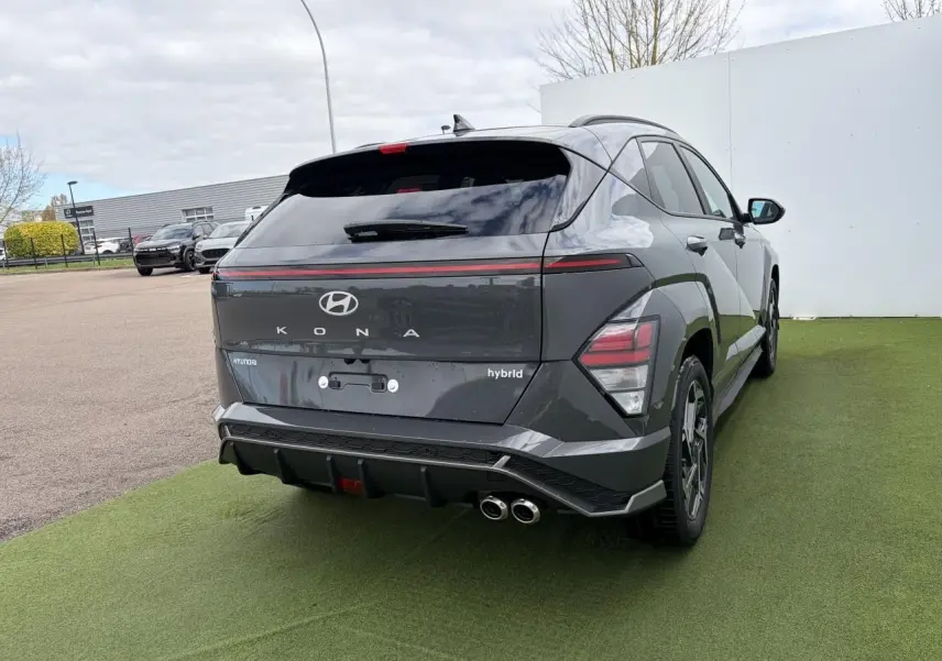 Vue 3/4 arrière droite du Hyundai KONA II hybride gris Ecotronic avec double sortie d'échappement et feux arrière LED.