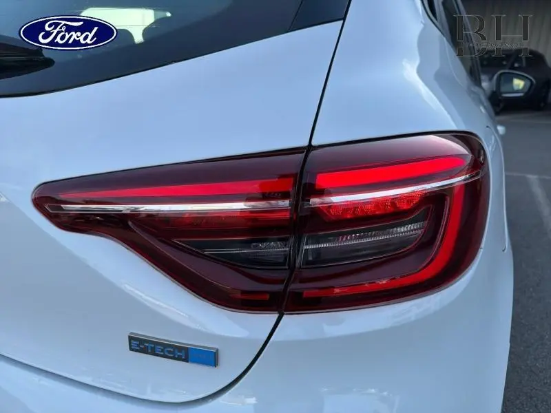 Gros plan sur le feu arrière droit rouge d'une Renault Clio blanche 1.6 E-Tech avec logo E-Tech visible.