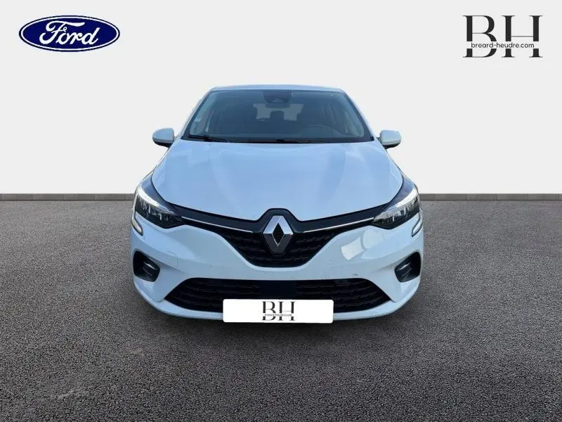 Vue avant d'une Renault Clio blanche 2021 avec calandre noire et phares LED distinctifs sur fond neutre.
