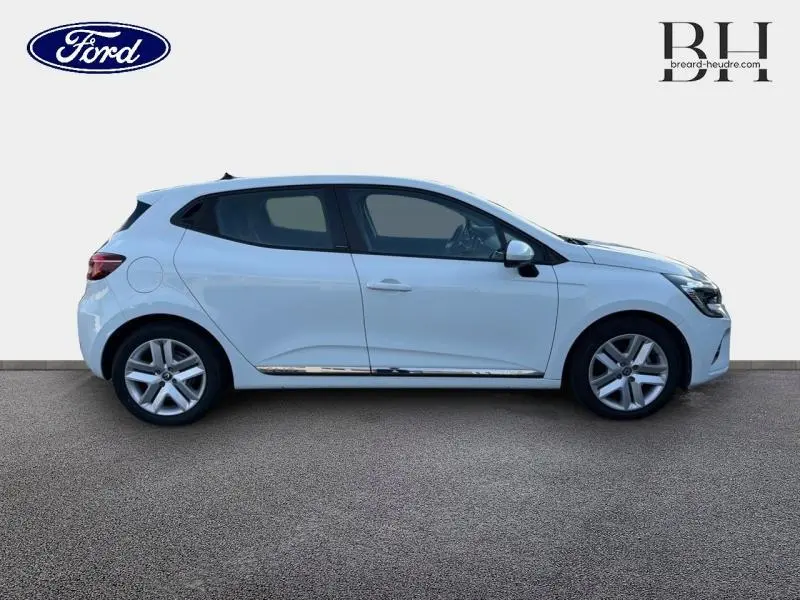 Profil côté droit d'une Renault Clio blanche 2021, version 1.6 E-Tech Business avec jantes alliage et vitres teintées.