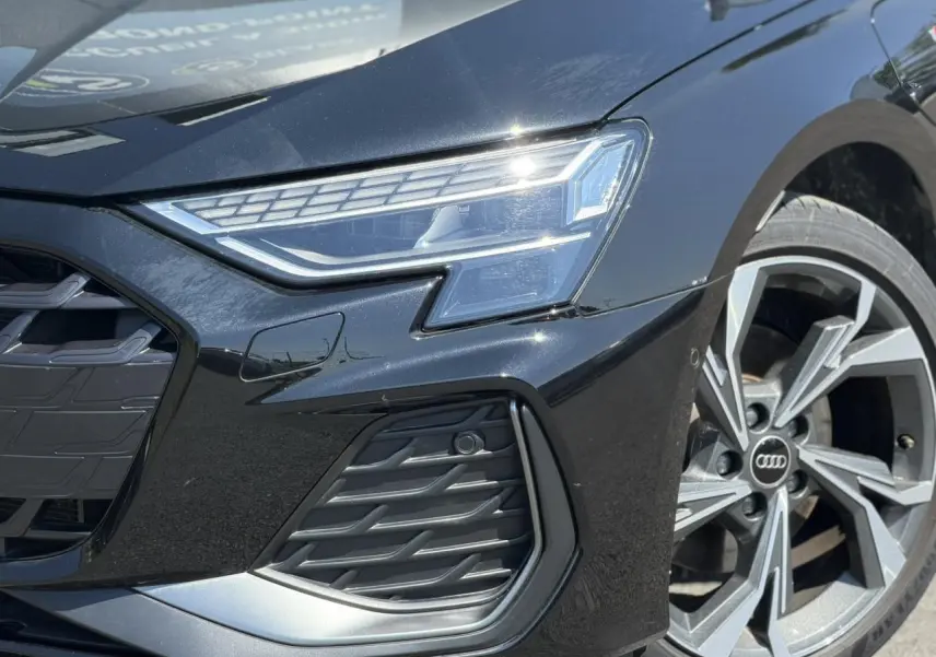 Gros plan sur l'avant droit noir Mythe de l'Audi A3 Sportback 2025 avec phares Matrix LED et jante alliage 18 pouces.