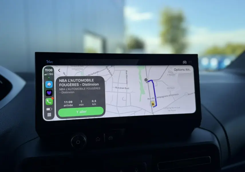 Vue intérieure centrée sur l'écran tactile 10 pouces affichant la navigation du Peugeot Partner blanc Icy 2026.