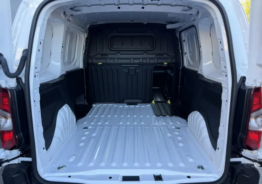 Vue arrière du coffre blanc Icy du Peugeot Partner 2026, montrant l'espace de chargement tôlé et les anneaux d'arrimage au sol.