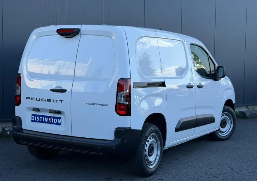 Vue 3/4 arrière droite du Peugeot Partner blanc Icy avec portes arrière battantes et protections latérales noires.