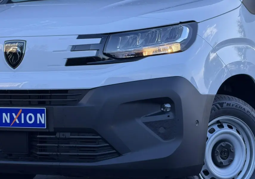 Gros plan sur l'avant droit blanc Icy du Peugeot Partner 2026 avec phare LED et pare-chocs noir mat.