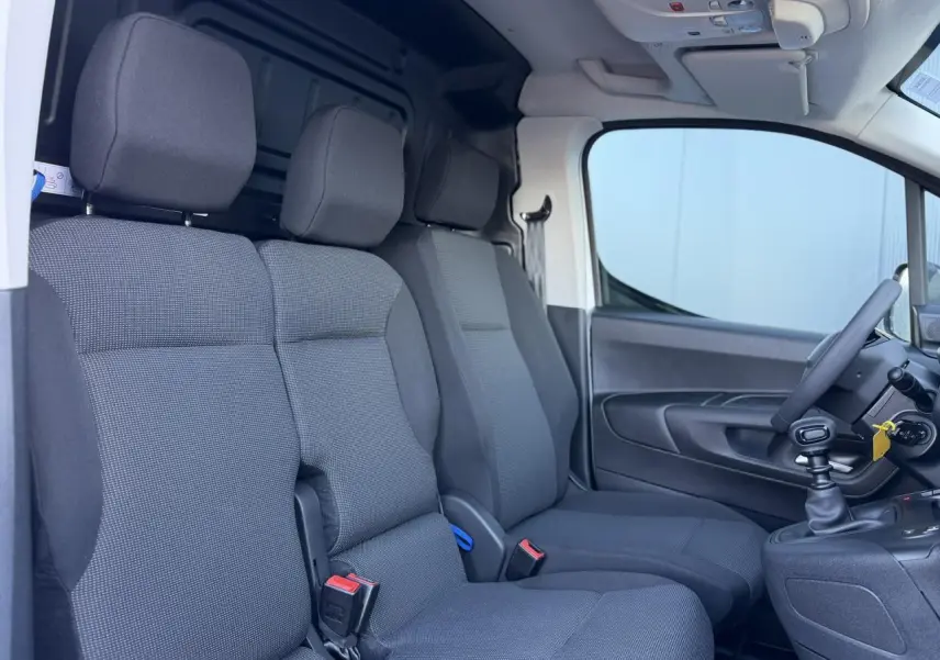 Vue intérieure côté droit du Peugeot Partner 2026 blanc Icy, montrant la banquette passager 2 places en tissu gris.