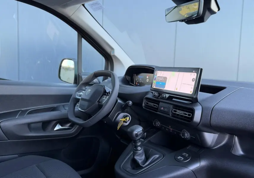 Vue intérieure côté conducteur du Peugeot Partner blanc Icy 2026, avec tableau de bord numérique et écran tactile central.