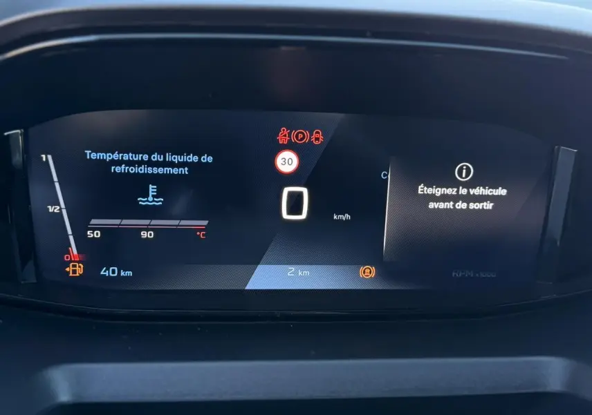 Affichage numérique du tableau de bord du Peugeot Partner 2026 montrant la température liquide de refroidissement et alertes véhicule.