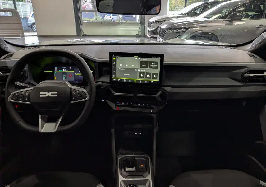 Vue intérieure frontale du tableau de bord du Dacia Duster blanc Glacier 2026 avec écran tactile central et volant multifonctions.
