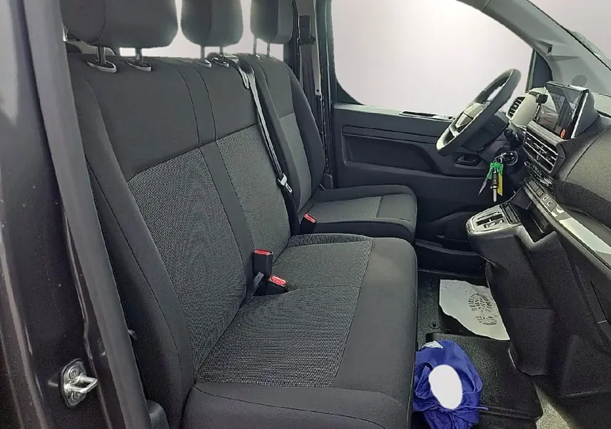 Intérieur du FIAT Scudo Combi 2026 vu côté conducteur, sièges bi-ton noir/gris et tableau de bord moderne.