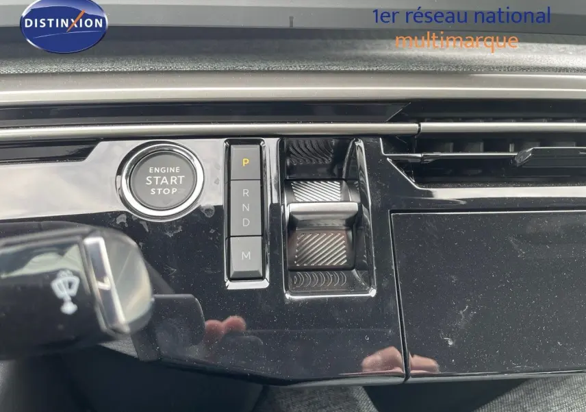 Détail de la console centrale noire brillante du Peugeot 3008 Hybrid 2025 avec bouton start/stop et commandes de boîte automatique.
