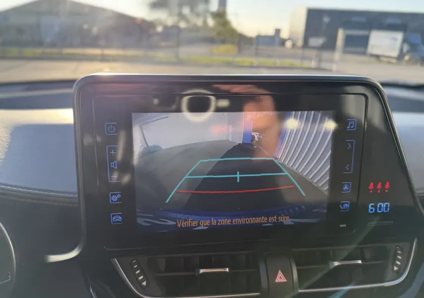 Écran tactile intérieur du Toyota C-HR bleu Nebula Metal montrant la caméra de recul avec lignes de guidage colorées.