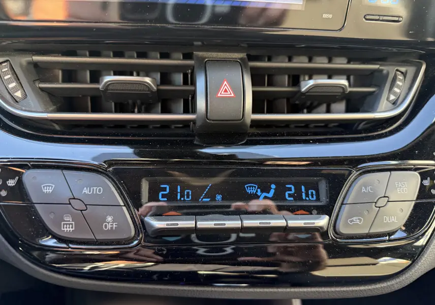 Gros plan sur la console centrale du Toyota C-HR bleu Nebula 2018, affichant la climatisation automatique à 21°C.