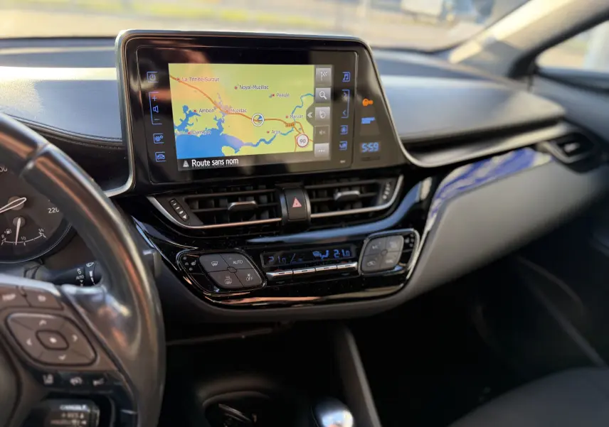 Vue rapprochée du tableau de bord du Toyota C-HR 2018 bleu Nebula Metal avec écran tactile et commandes climatisation.