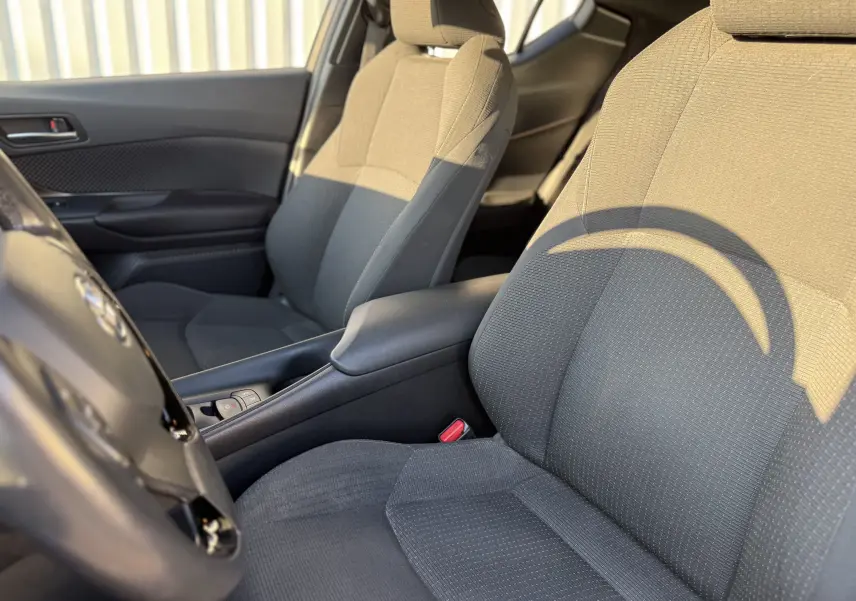 Vue rapprochée des sièges avant en tissu gris foncé de la Toyota C-HR 1.8 Hybrid Business 2018.