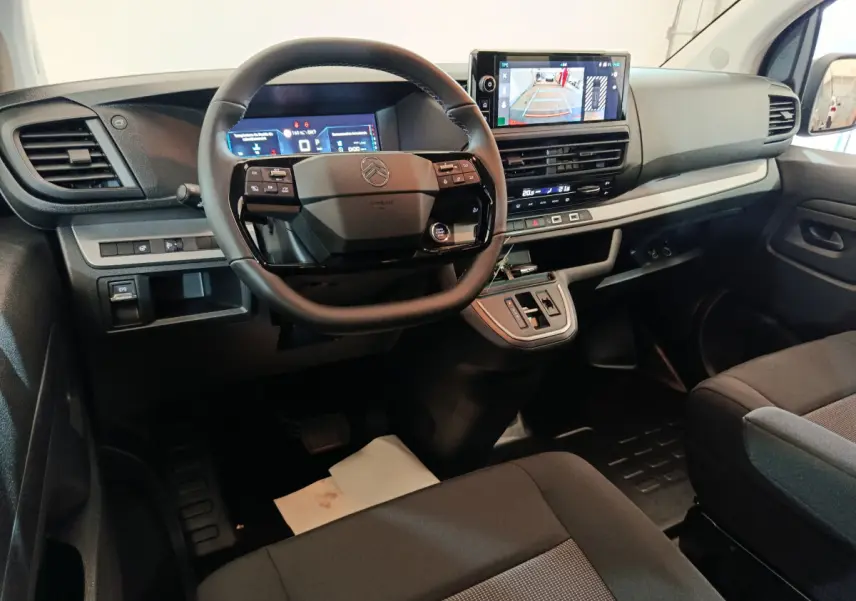 Intérieur du Citroën Jumpy XL 2025 vu de face, tableau de bord noir avec écran tactile et volant multifonctions.