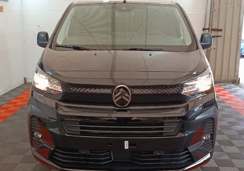 Vue avant du Citroën Jumpy XL noir 2025 avec phares allumés et calandre distinctive dans un garage.