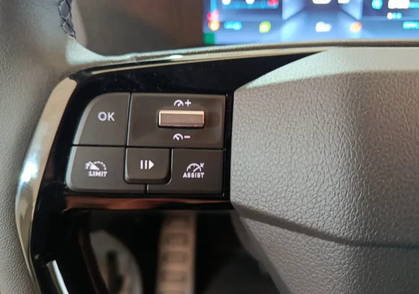 Gros plan sur les commandes noires du volant côté gauche du Citroën Jumpy XL 2025 avec affichage numérique flou en arrière-plan.