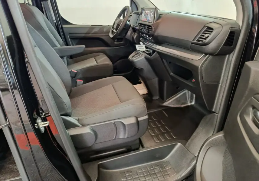 Vue intérieure côté conducteur du Citroën Jumpy XL noir 2025, montrant les sièges avant et le tableau de bord moderne.