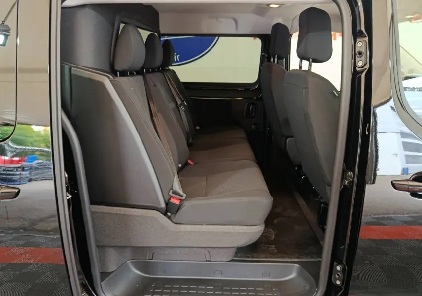 Vue latérale intérieure du Citroën Jumpy XL noir, montrant la banquette arrière 3 places et la cloison vitrée.