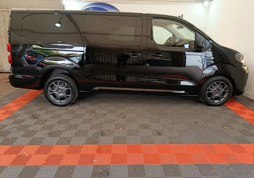 Vue latérale droite d’un Citroën Jumpy XL noir 2025 avec jantes gris foncé et carrosserie lisse sans vitres arrière.