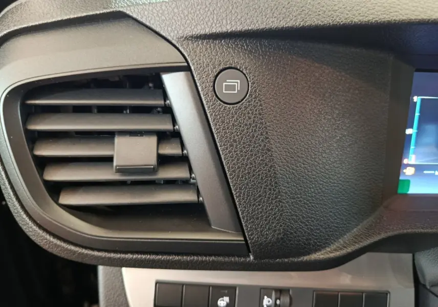 Détail intérieur du tableau de bord noir du Citroën Jumpy 2025, avec sortie d’air et bouton de commande carré.