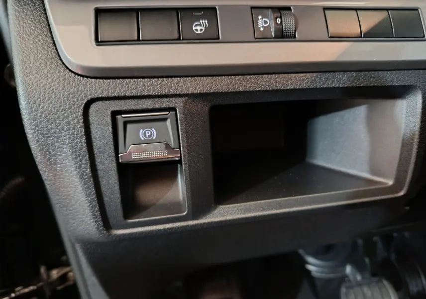 Détail du tableau de bord noir du Citroën Jumpy XL 2025, avec bouton de frein à main électrique et commandes d'éclairage.