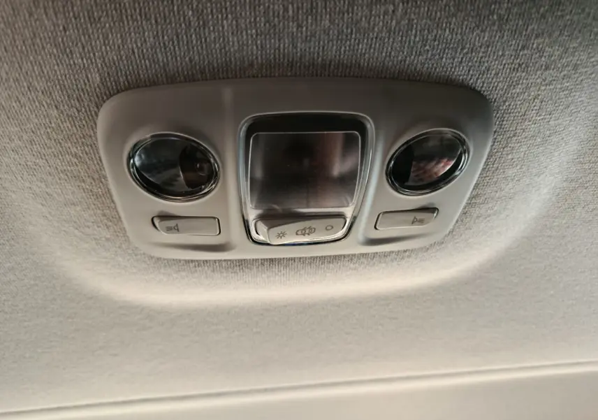 Plafonnier intérieur gris clair avec deux lampes rondes et boutons de commande dans un Citroën Jumpy XL noir.