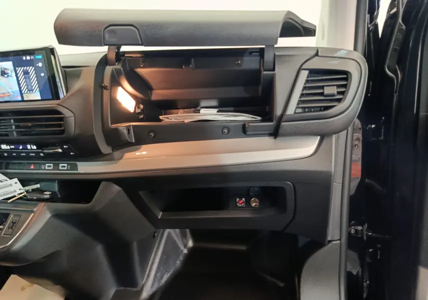 Intérieur du Citroën Jumpy XL 2025, vue côté passager avec boîte à gants ouverte et éclairage intérieur allumé.