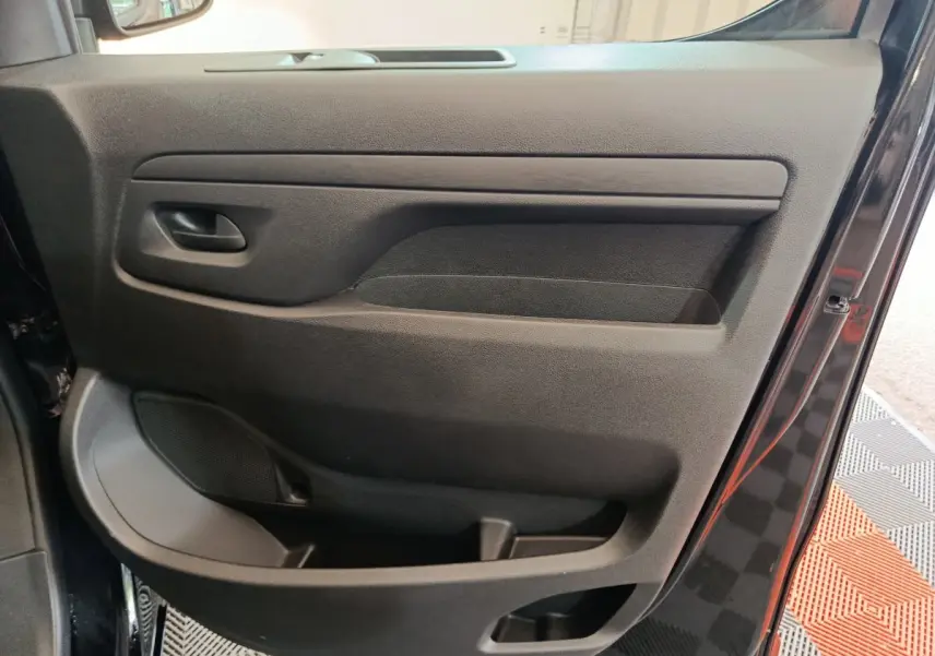 Vue intérieure de la porte avant droite noire du Citroën Jumpy XL 2025, avec poignée et rangement intégré.