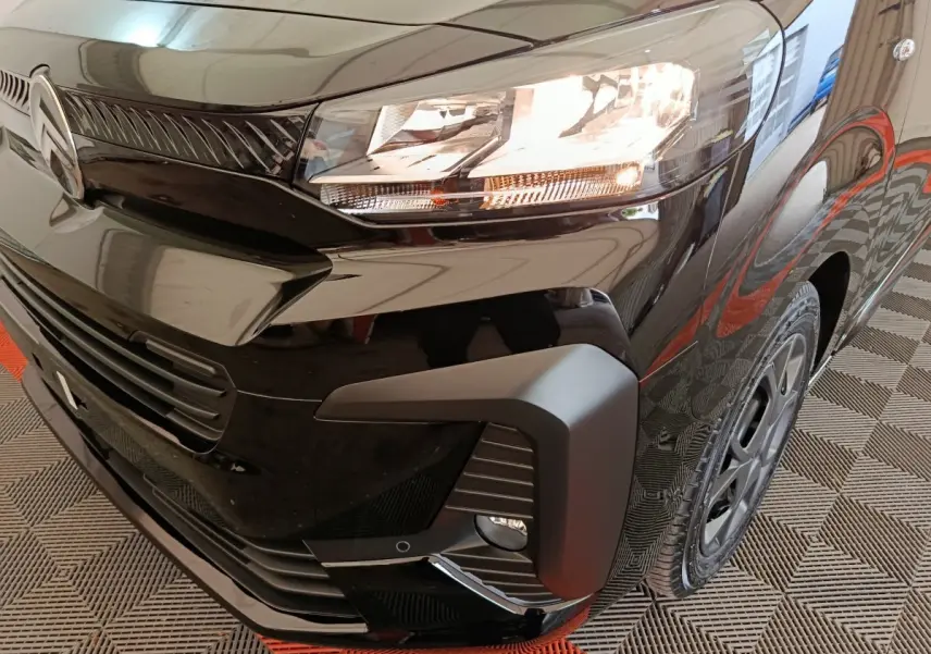 Gros plan sur l'avant droit noir brillant du Citroën Jumpy XL 2025, mettant en valeur le phare et la calandre.