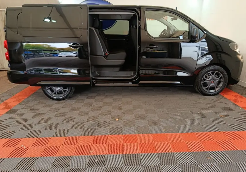 Profil gauche d’un Citroën Jumpy XL noir 2025 avec porte coulissante ouverte dévoilant la banquette arrière.
