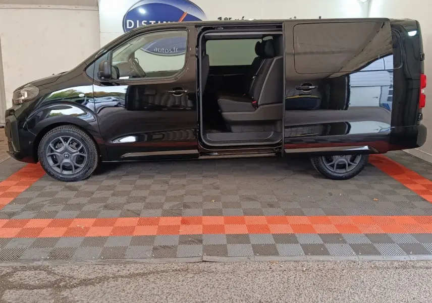 Vue latérale droite d'un Citroën Jumpy XL noir 2025 avec porte coulissante ouverte révélant la banquette arrière.