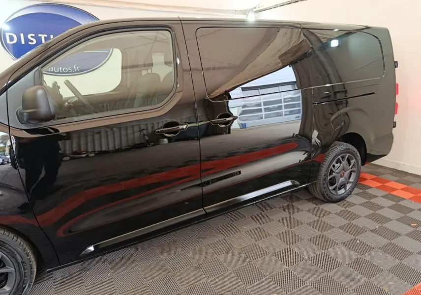 Vue de profil côté gauche du Citroën Jumpy XL noir, mettant en valeur sa carrosserie lisse et ses jantes noires.