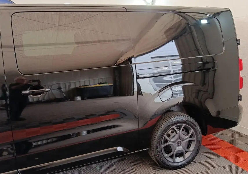 Vue latérale droite d’un Citroën Jumpy XL noir avec porte coulissante et jante alliage distinctive.
