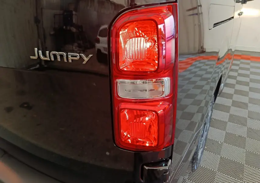 Gros plan sur le feu arrière droit et le logo Jumpy d’un Citroën Jumpy XL noir, vue arrière côté droit.
