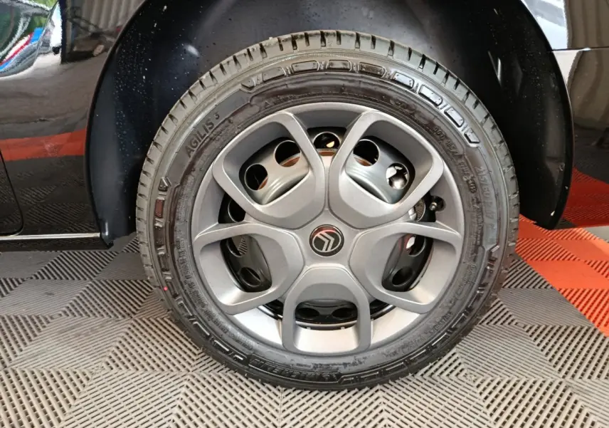 Gros plan sur la roue avant droite noire d’un Citroën Jumpy XL 2025, mettant en valeur la jante grise au design moderne.