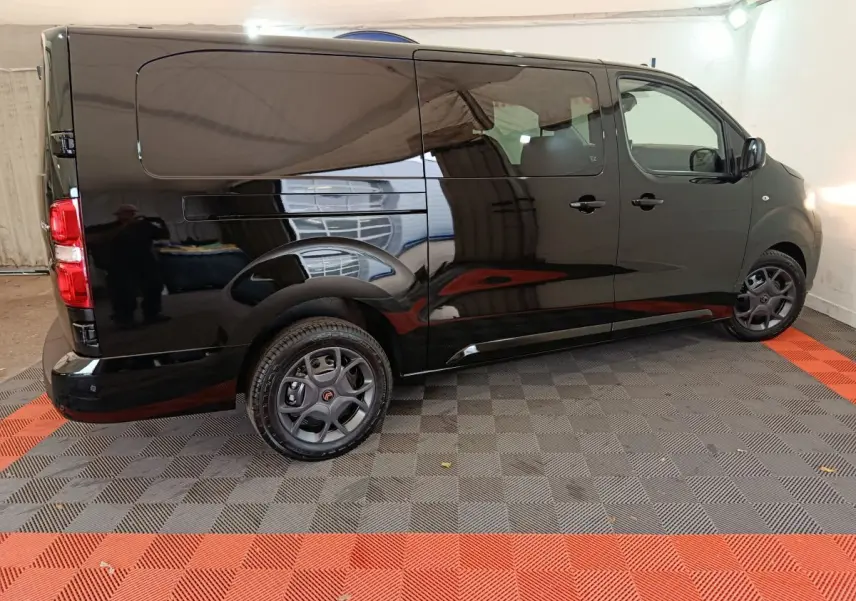 Vue de profil côté droit d'un Citroën Jumpy XL noir 2025 avec jantes foncées et porte latérale coulissante.