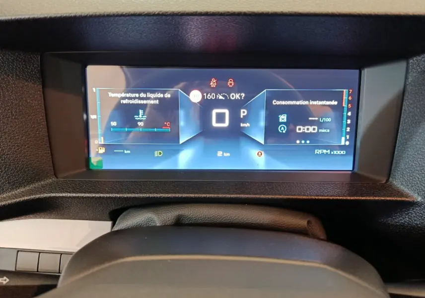 Vue rapprochée du tableau de bord numérique du Citroën Jumpy noir, affichant la température moteur et la consommation instantanée.