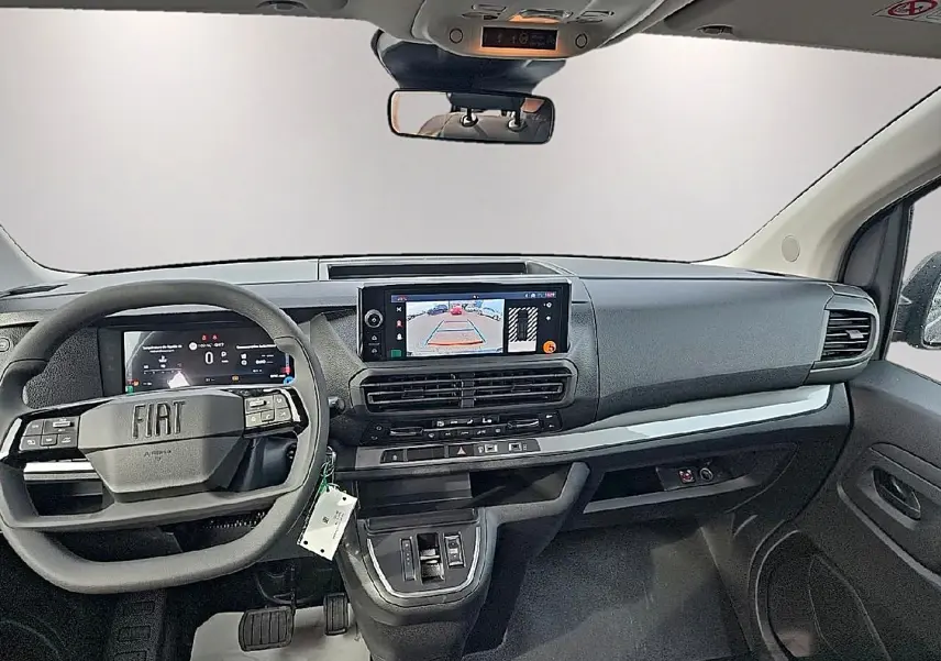 Vue intérieure avant du Fiat Scudo Combi gris titane 2026, tableau de bord moderne avec écran tactile et volant multifonctions.