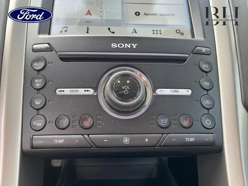 Gros plan sur la console centrale noire avec commandes Sony du Ford Mondeo gris Magnetic, affichage tactile et réglages climatiques.