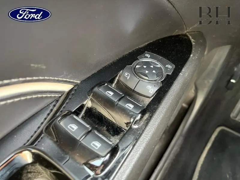 Gros plan sur les commandes de vitres et rétroviseurs côté conducteur d'une Ford Mondeo gris Magnetic 2018.